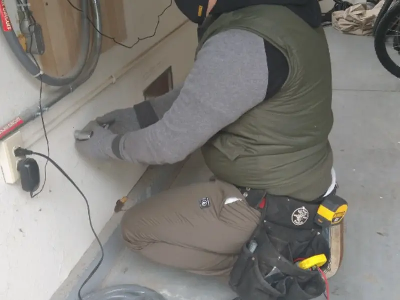 Electrician performing outlet wiring in a Heflin garage